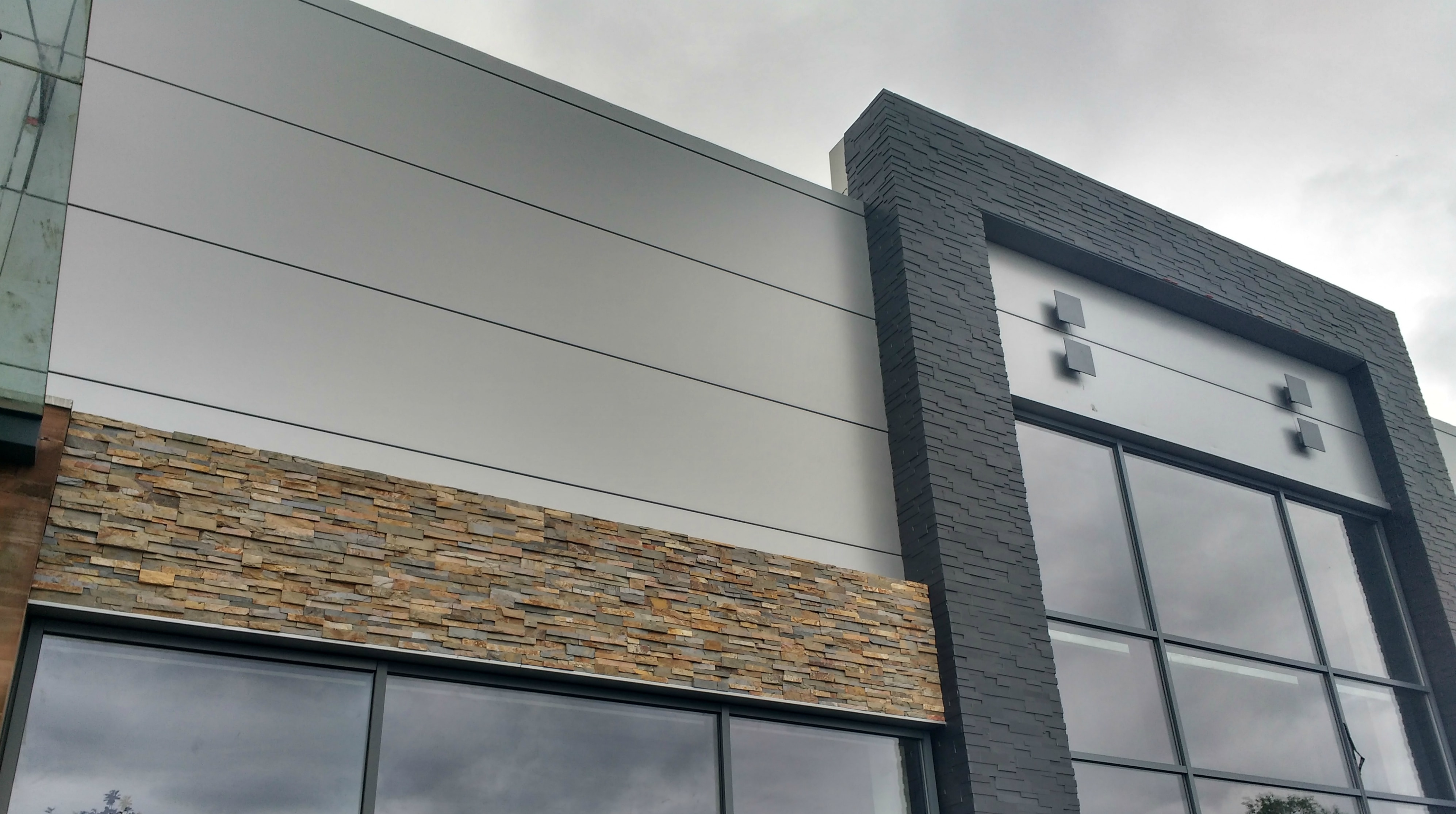 Smooth and naturally textured stone veneer used as part of a modern inspired commercial facade